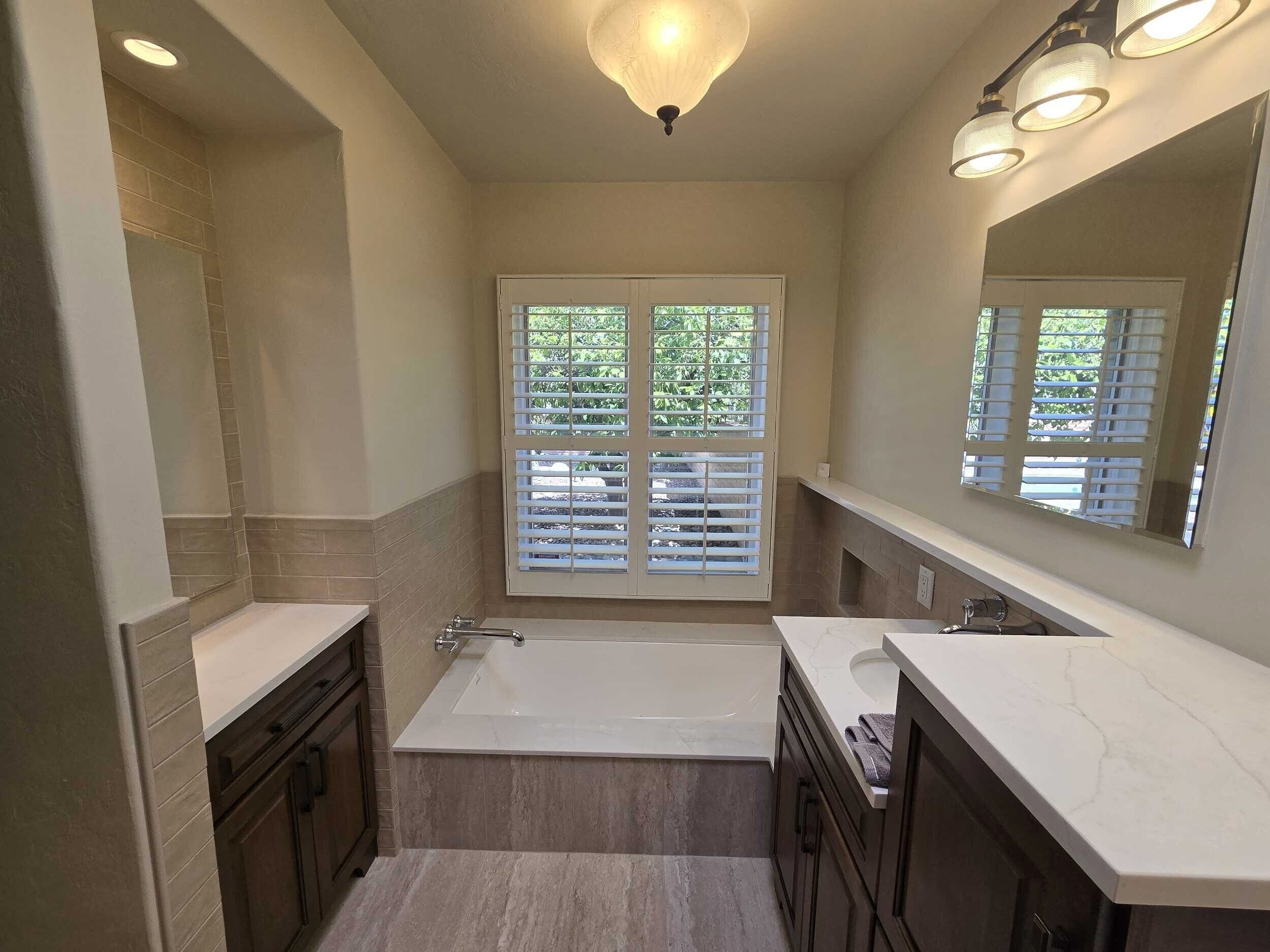Completed master bathroom remodel with soaking tub, dual vanities, and plantation shutters — Birchard Remodeling Tucson