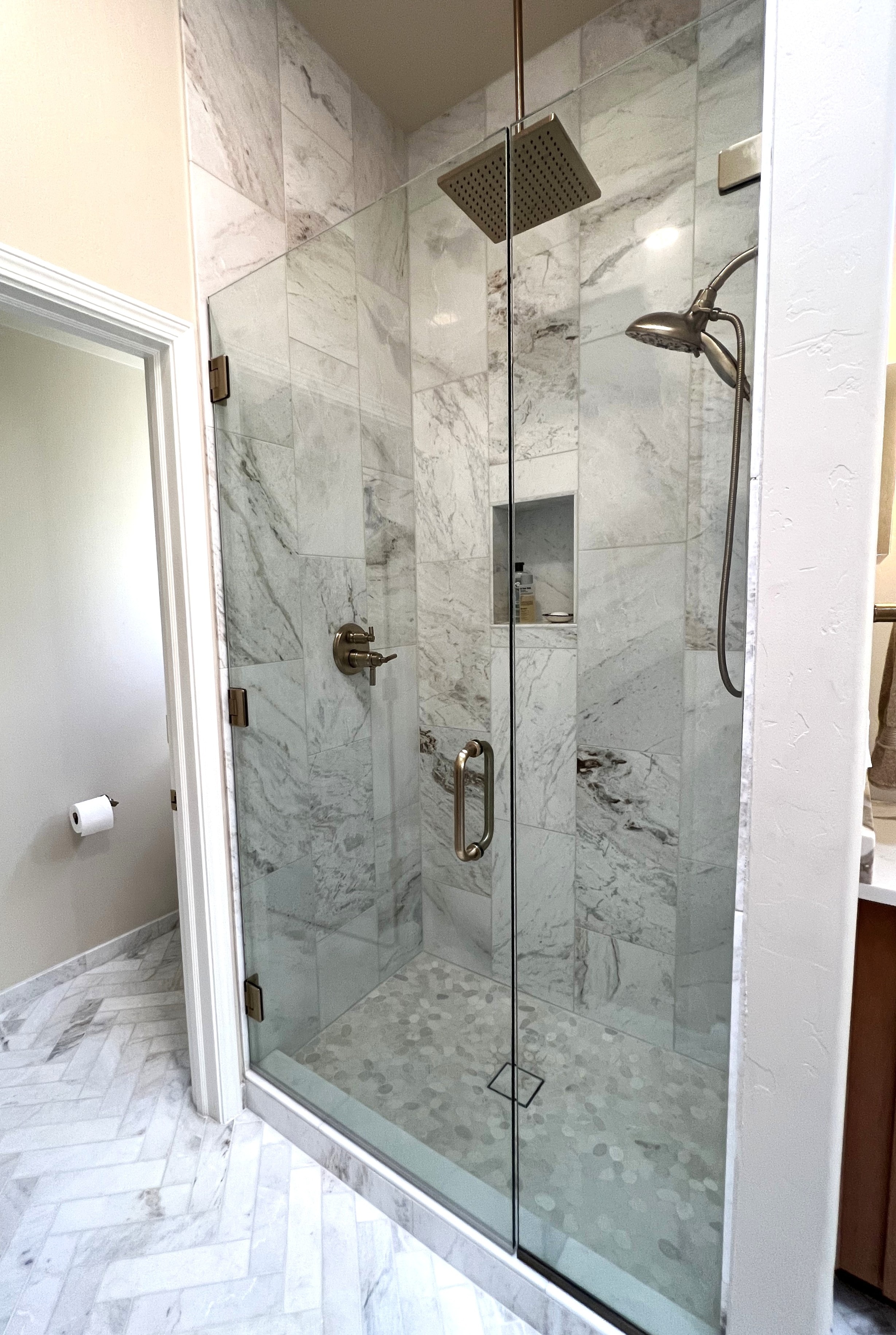 Custom marble tile walk-in shower with glass door and rain head — Birchard Remodeling Tucson