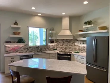 White kitchen remodel with quartz countertops, mosaic backsplash, and open shelving — Birchard Remodeling Tucson