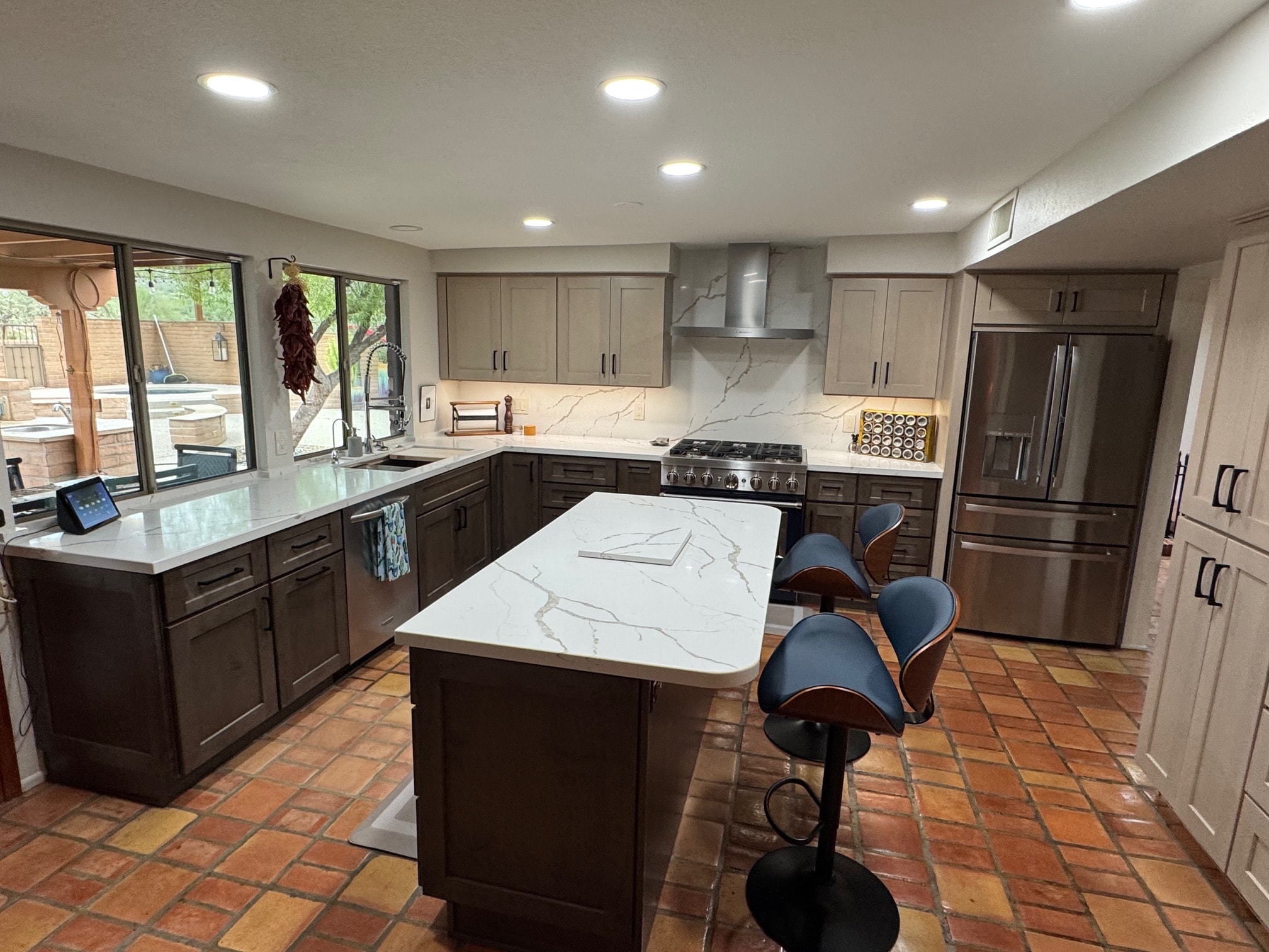 Taupe shaker kitchen with Calacatta quartz island, stainless appliances, and Saltillo tile — Birchard Remodeling Tucson